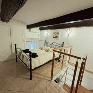 La chambre à l'étage sous les poutres apparentes du XVIIIe siècle