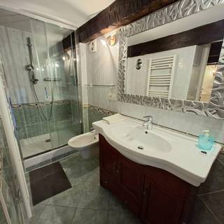 La salle de bain avec douche à l'italienne et grand miroir