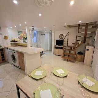 La table dressée face à la cuisine, au coin télévision et à l'escalier